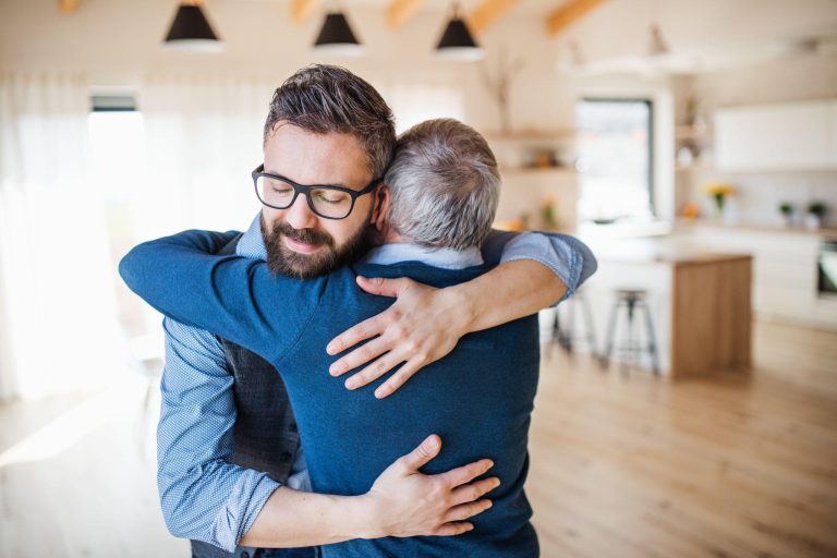 adult son hugging his biological father