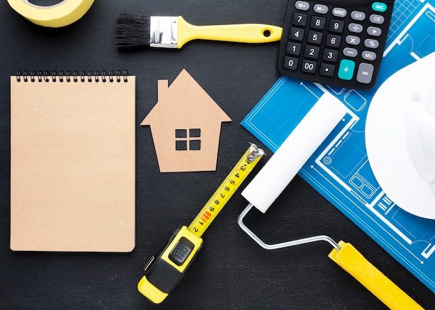 Blue print of a house with tools and empty notepad
